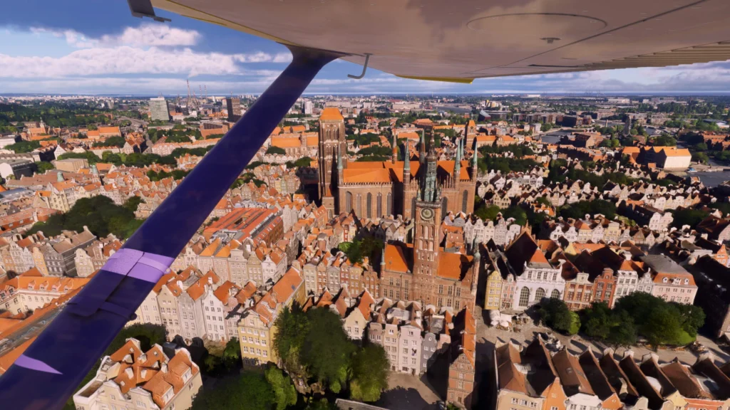 View from an aircraft over the densely built old town of Gdańsk in Microsoft Flight Simulator 2024.